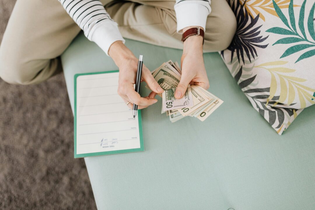 Person holding cash and reviewing documents, representing financial proof requirement under the 3000 Dirham rule UAE for travellers.