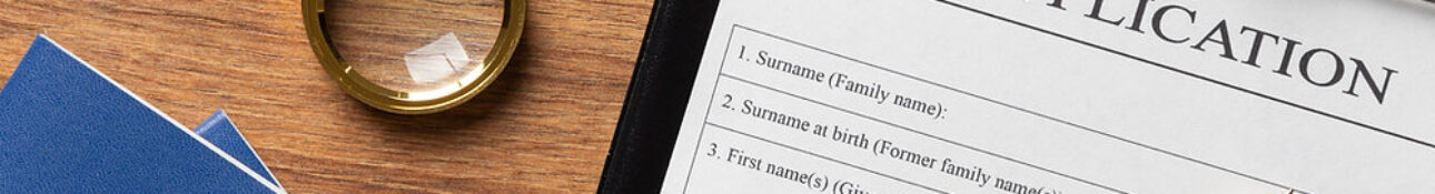 Ukraine Visa Application form with passport, pen, and magnifying glass on a wooden desk.